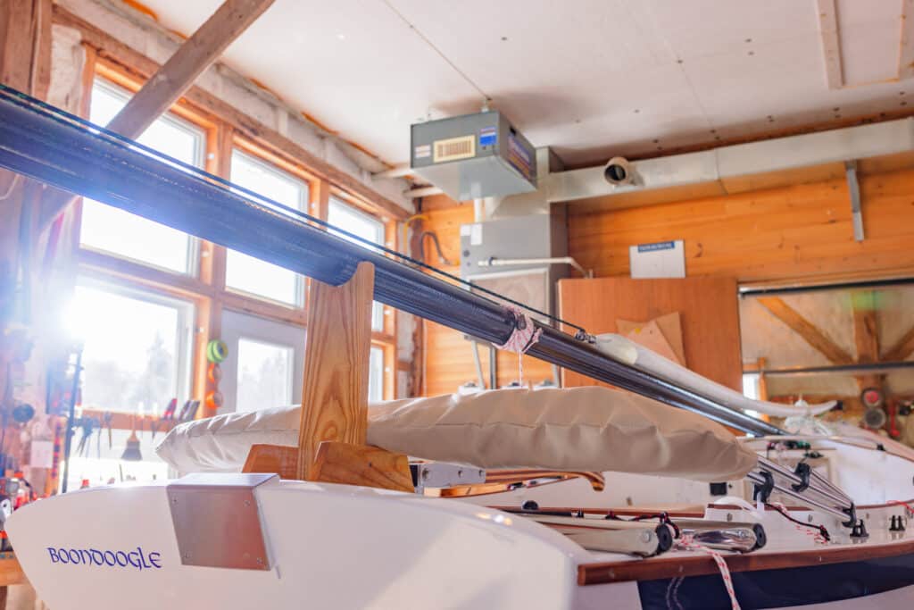 Close-up of a NorseBoat 17.5 Classic in their shop in PEI, Canada; focusing on the carbon mast, detail work, and classic lines.